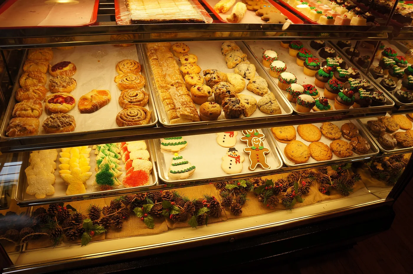 A bakery display case of pastries, muffins, cupcakes and decorated cookies. The photo was not taken in Jacksonville.