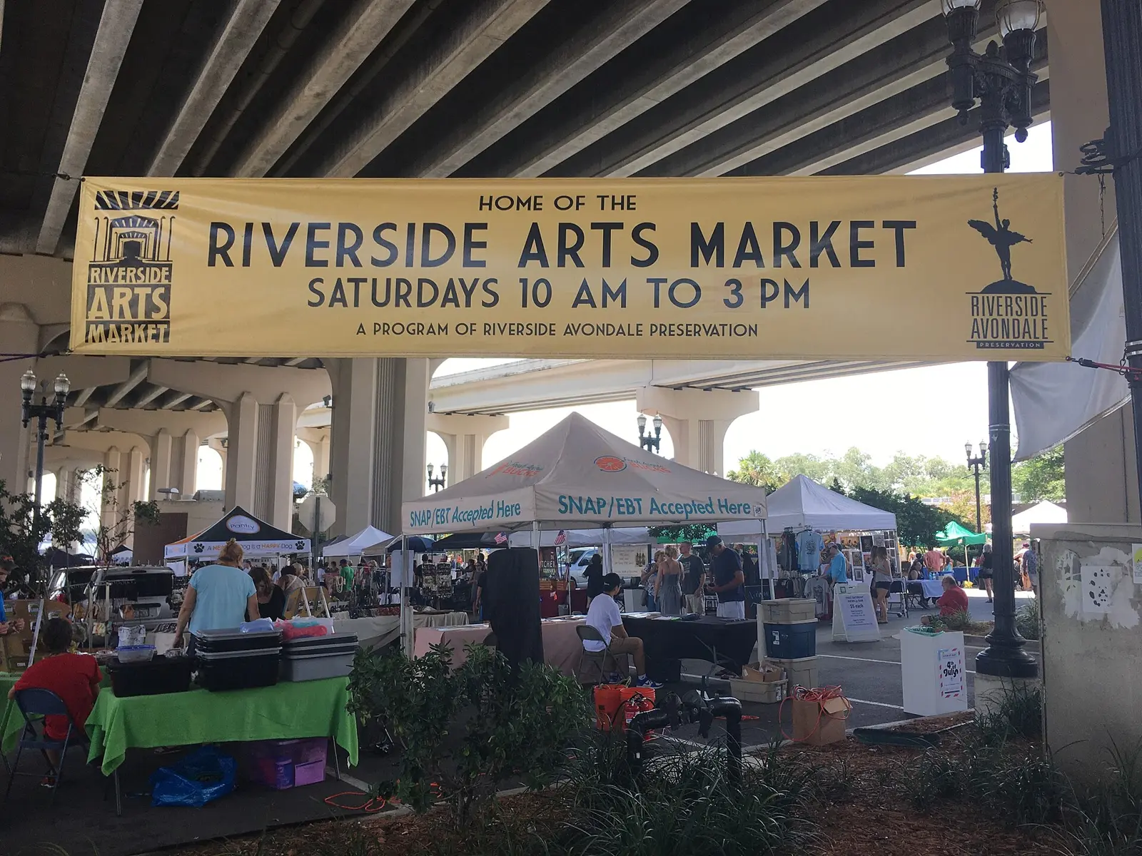 Vendors set up under the Fuller Warren Bridge at the Riverside Arts Market in Jacksonville.