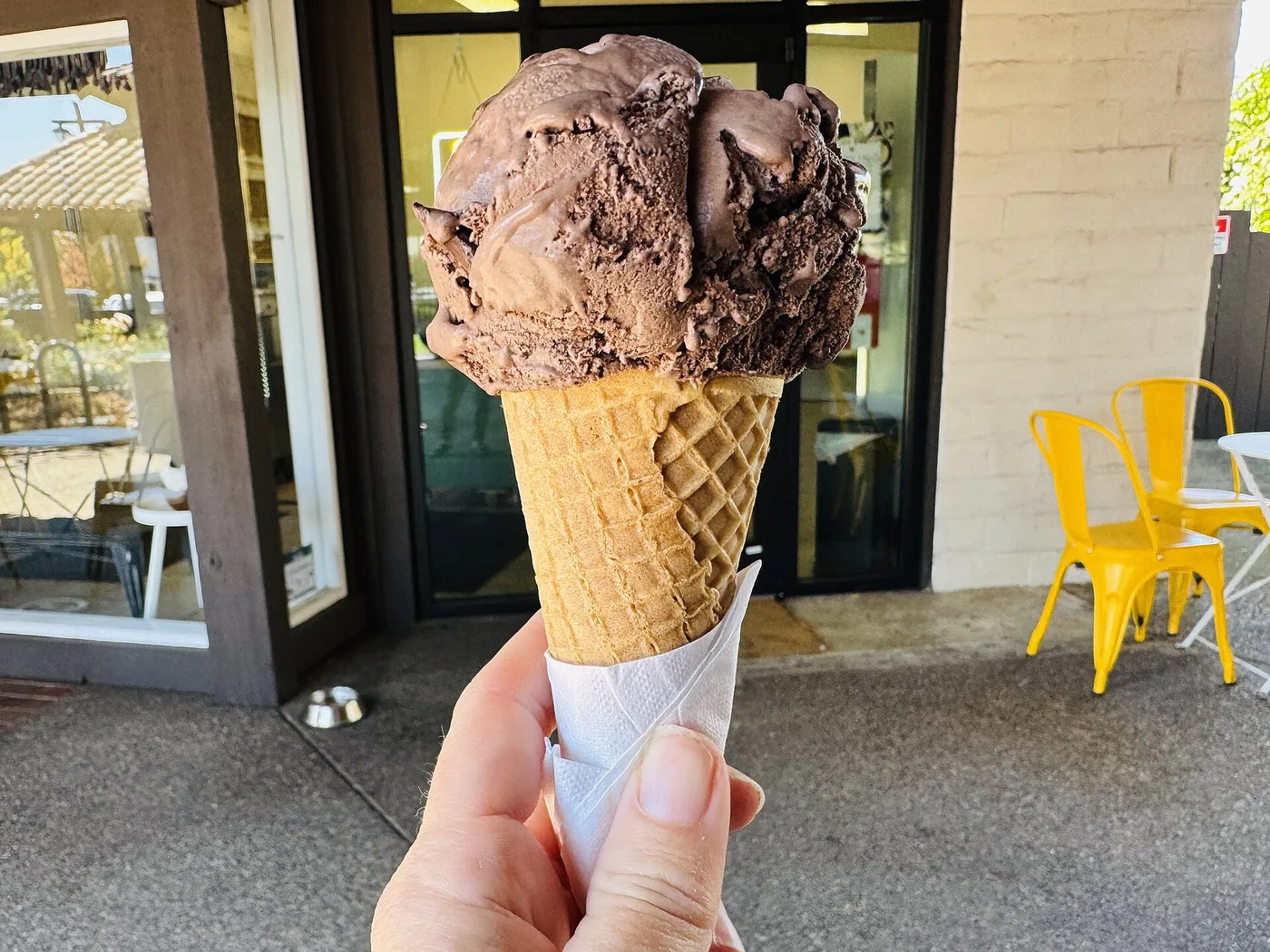 A chocolate ice cream cone outside an ice cream shop. The photo was not taken in Jacksonville.