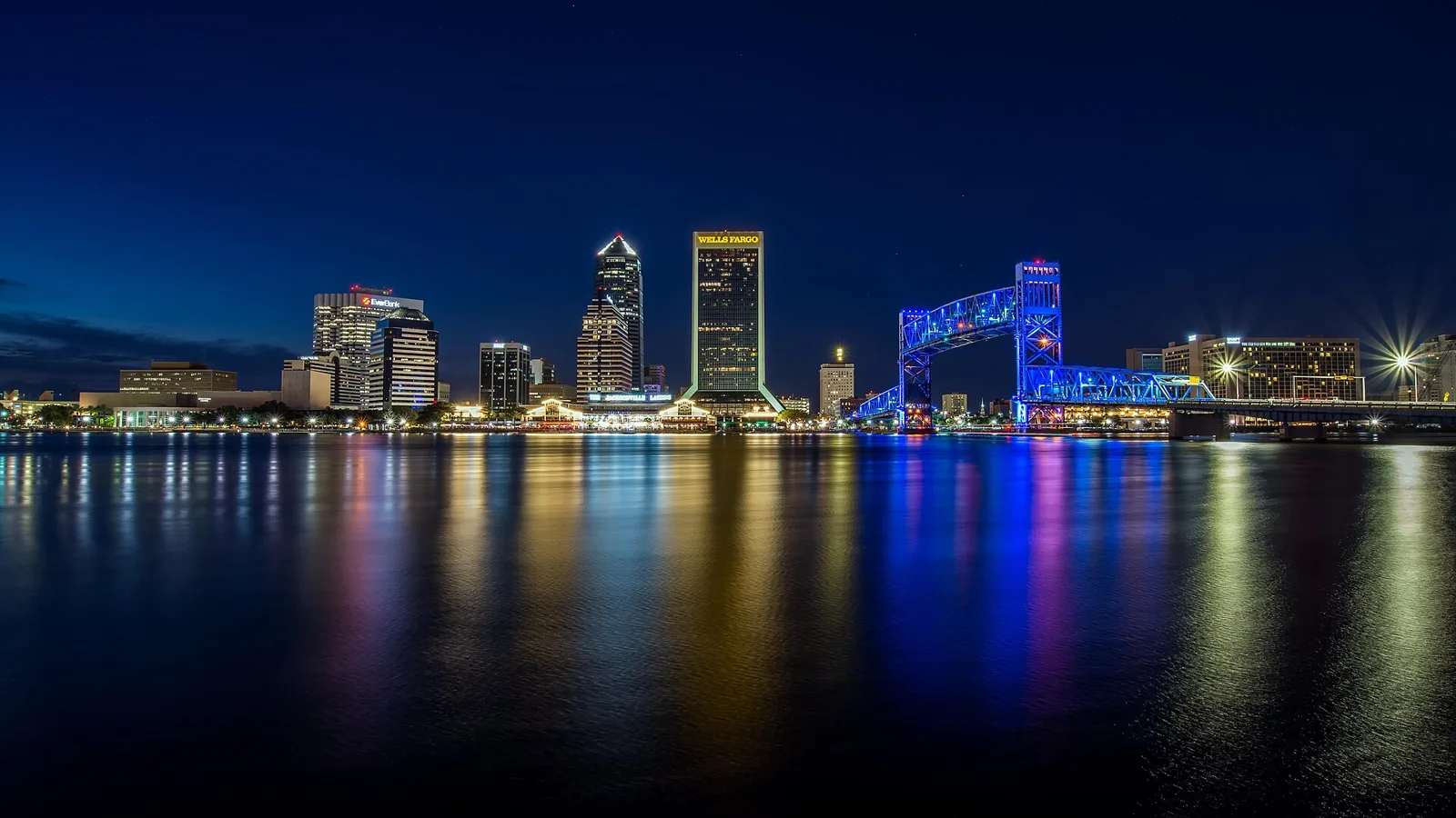 The downtown Jacksonville skyline and the Main Street Bridge reflected in the St. Johns River at night.