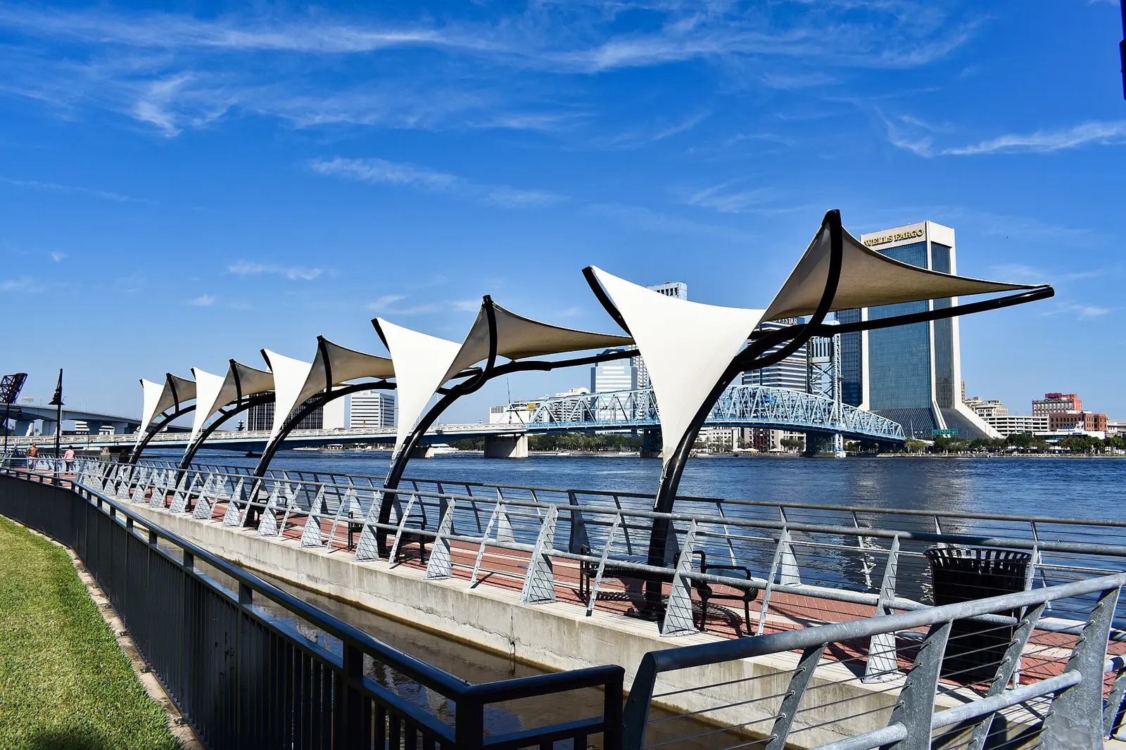 Shade sails along the Southbank Riverwalk, looking across the St. Johns River to downtown Jacksonville and the Main Street Bridge.