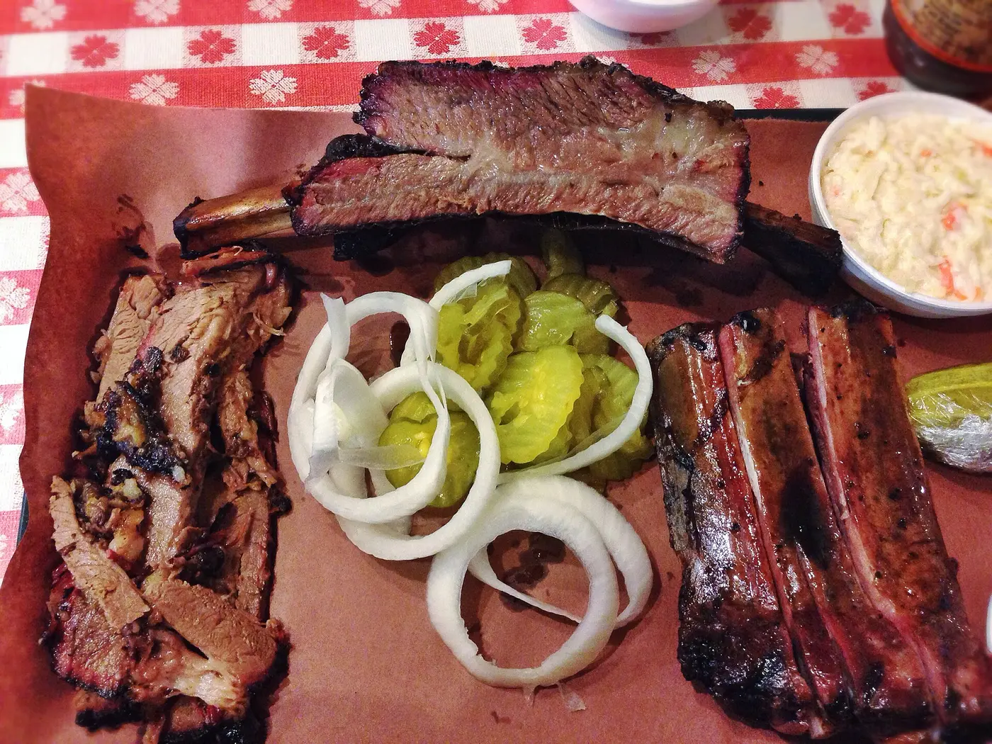 A barbecue plate of brisket, beef rib and pork ribs with pickles, onion and coleslaw. The photo was taken in Texas, not at a Jacksonville restaurant.